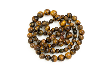 Necklace made of decorative tiger eye stone twisted on white background isolated