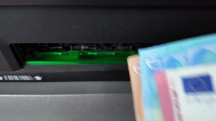Close-up view then withdrawing euro banknotes from ATM after accepted, France. - Powered by Adobe