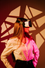 Woman immerses herself in a digital world wearing virtual reality glasses against a colorful...