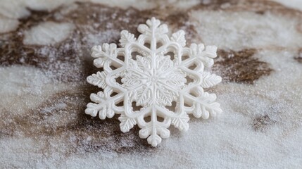 White snowflake decoration on a textured marble surface with a dusting of powdered sugar Copy Space