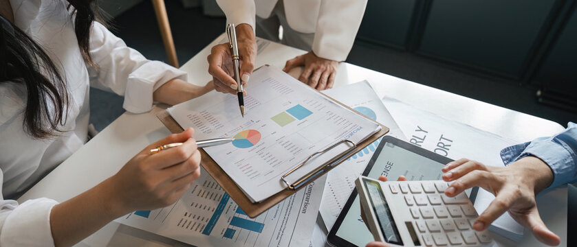 Detail oriented team reviewing financial reports and data analysis during a collaborative business meeting