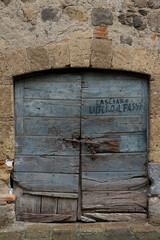 Old and very worn wooden doors on a brick wall
