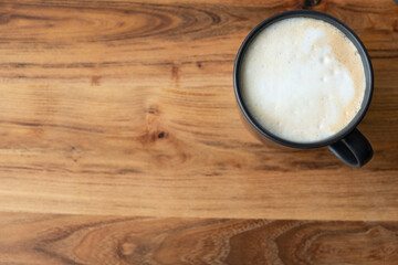 cropped shot of a cup of coffee on wood background