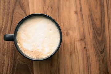 cropped shot of a cup of coffee on wood background