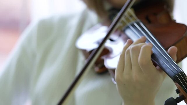 Woman fiddler playing violin quickly with bow, focused on performance. Female practicing acoustics skills, musical expression, speed and precision on concert, instrument mastery, music rehearsal