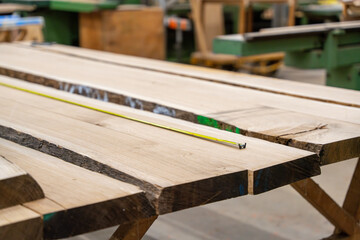 Gros plan de gestes pr&eacute;cis et de mat&eacute;riaux en bois dans un atelier de menuiserie, capturant l'artisanat du bois &agrave; l'&oelig;uvre.