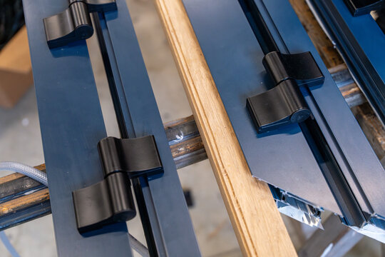 Fabrication de menuiserie en aluminium dans un atelier, avec des artisans coupant et assemblant des profils m&eacute;talliques pour des fen&ecirc;tres et portes.