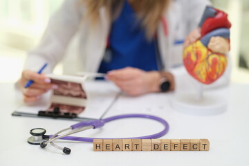 A skilled medical professional thoroughly examines heart defect images using a stethoscope and a...