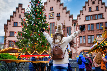 A happy woman stands at the traditional Christmas market on the Römer in the old town of...