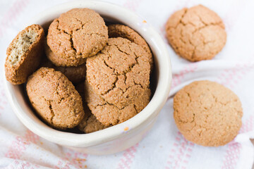 A bowl full of gluten-free homemade oatmeal cookies in close-up. Shallow depth of field..