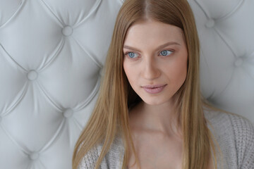 Beauty portrait. Young woman on grey wall background.