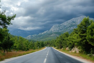 Fototapeta premium Mountain road winding through scenic nature with green hills and clouds in the sky