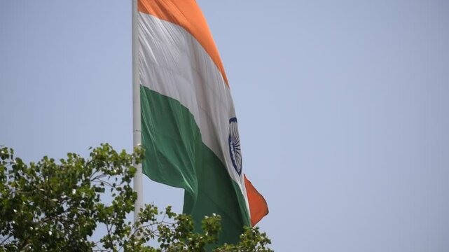 India flag flying high at Connaught Place with pride in blue sky, India flag fluttering, Indian Flag on Independence Day and Republic Day of India, tilt up shot, Waving Indian flag, Har Ghar Tiranga