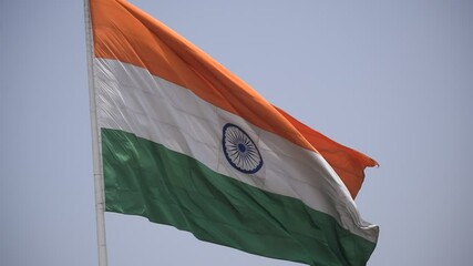 India flag flying high at Connaught Place with pride in blue sky, India flag fluttering, Indian Flag on Independence Day and Republic Day of India, tilt up shot, Waving Indian flag, Har Ghar Tiranga