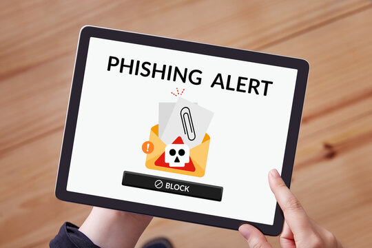 Phishing alert displayed on a tablet held by a woman's hands at home, symbolizing online scam warnings.