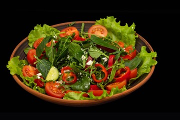 Greek vegetable salad with feta cheese, tomatoes, cucumbers, onions, olive oil on a black background