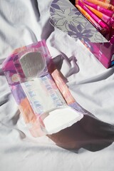 Sanitary pad and tampons on fabric. © Wirestock
