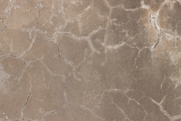 A cracked and worn concrete surface with a few small holes