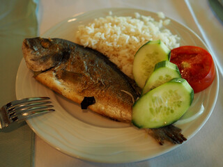 Sea bass dorado, sea bass with rice and vegetables on a plate