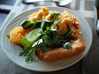 Scrambled eggs with herbs and cucumbers, toast for breakfast