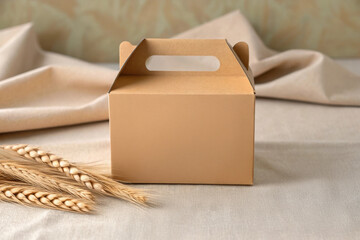 Cardboard Box on a Neutral Linen Fabric With Wheat Stalks