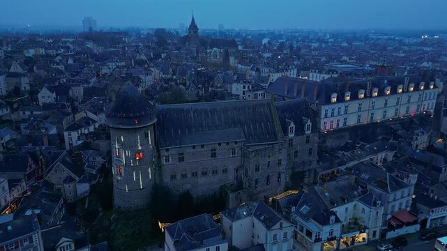 Evening time in Laval, Christmas urban decorations and illuminations, Laval castle and riverside, Mayenne in France. Aerial drone forward