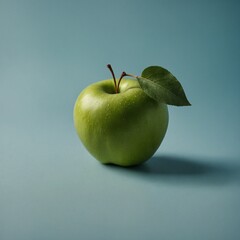 A green apple with a single leaf on a light blue background.