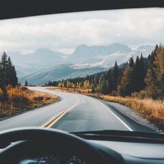 Fototapeta premium A scenic road trip view from a car dashboard, winding roads, and mountains ahead.