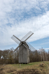 Obraz premium Classic windmill in a tranquil rural area with soft lighting and natural surroundings. A timeless symbol of heritage, eco-friendly energy, and countryside charm.