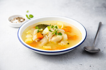 Clear soup with white fish and vegetables