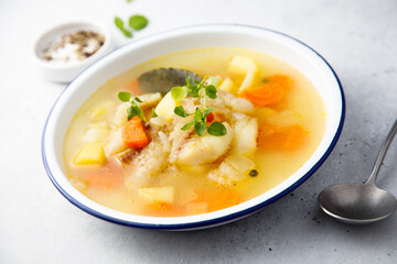 Clear soup with white fish and vegetables
