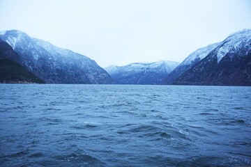 Obraz premium Snowy Fjord with Windy Waters and Towering Mountains on a Winter Day 