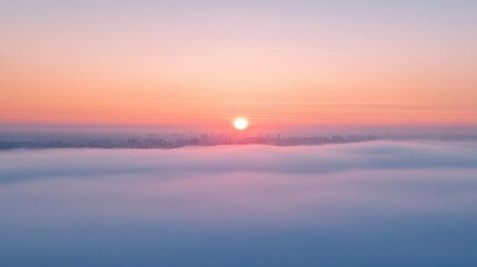 Obraz premium Breathtaking sunrise over city skyline shrouded in soft fog, creating serene atmosphere