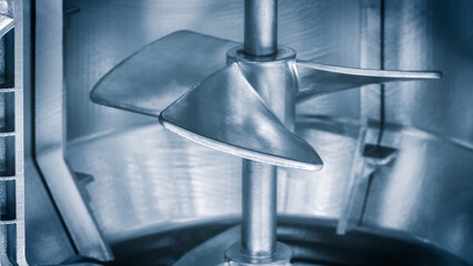 A silver propeller is shown in a blue background. The propeller is in a machine and is the main focus of the image © Aleksandr Matveev