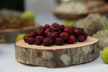 Background of a wooden coaster topped with dried cranberries, showcasing their rich red and natural texture. This is rustic composition, beauty of snacks, perfect for autumn and winter themes.