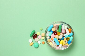 Various pills in a bowl on color background