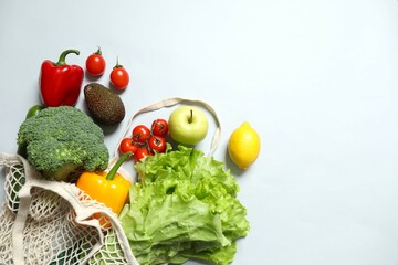 String bag with vegetables and fruits on gray background