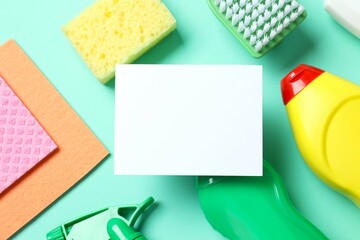 Many different house cleaning products with paper card on color background, top view