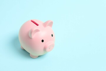 Piggy coin bank on colored background for money savings, financial security or personal funds concept.