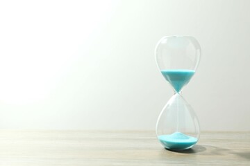Modern hourglass on the table. Hourglass time concept for business deadline, urgency and outcome of...