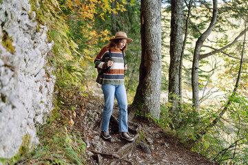 Woman with backpack hiking outdoors in the Forest. Trekking in the Pine Woods. Hiking, recreation and sports in nature.