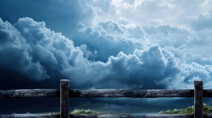Fototapeta premium Dark, dramatic clouds loom over a wooden fence in a serene landscape.