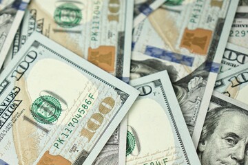 American hundred dollar paper money lies on the office table. Close-up of 100 American dollar bills. Currency exchange one hundred dollars. Investment, finance and income concept.