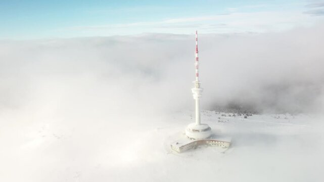 Transmission And Lookout Tower Shrouded By Fog And Clouds During Winter In The Peak Of Praded Mountain In Czech Republic. - aerial shot