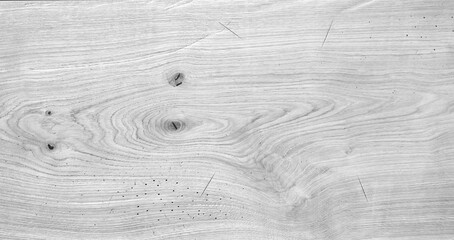 A wooden board with a grain pattern and a few knots. The board is white and has a natural texture