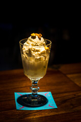 ice cream served with toasted peanuts on top and in  tall glass