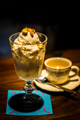 ice cream served with toasted peanuts on top and in  tall glass