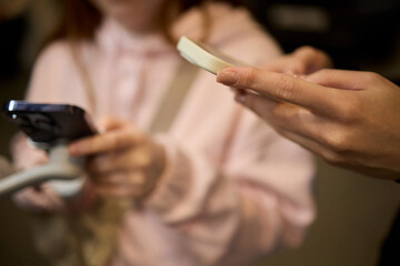 An Intimate Close Up of Hands Firmly Holding a Smartphone in a Soft Dim Light Environment