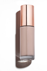 Foundation cosmetic glass bottle with golden cap. copy space, tone cream, moisturizer concept, isolated on white background with shadows. Trendy makeup product presentation