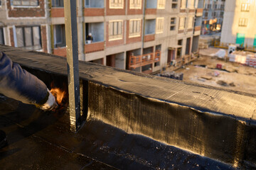 A construction worker skillfully applying waterproofing material on a rooftop surface
